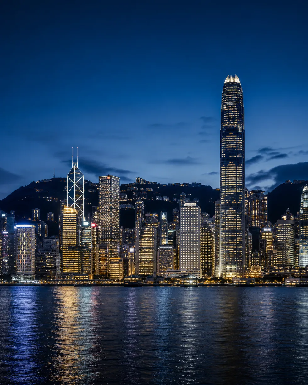 Hong Kong skyline across Victoria Harbour at night.