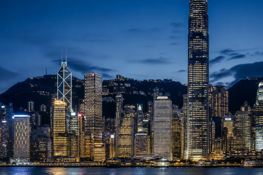 Hong Kong skyline across Victoria Harbour at night.