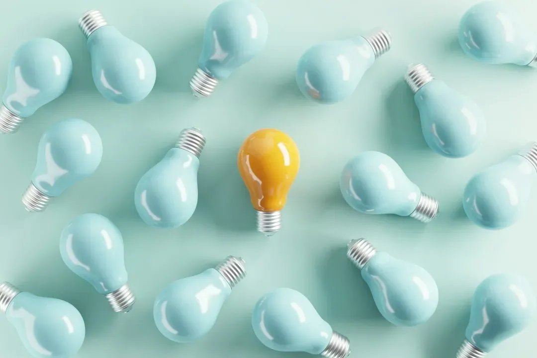 A yellow light bulb among pale bulbs, representing long-term operating insight.