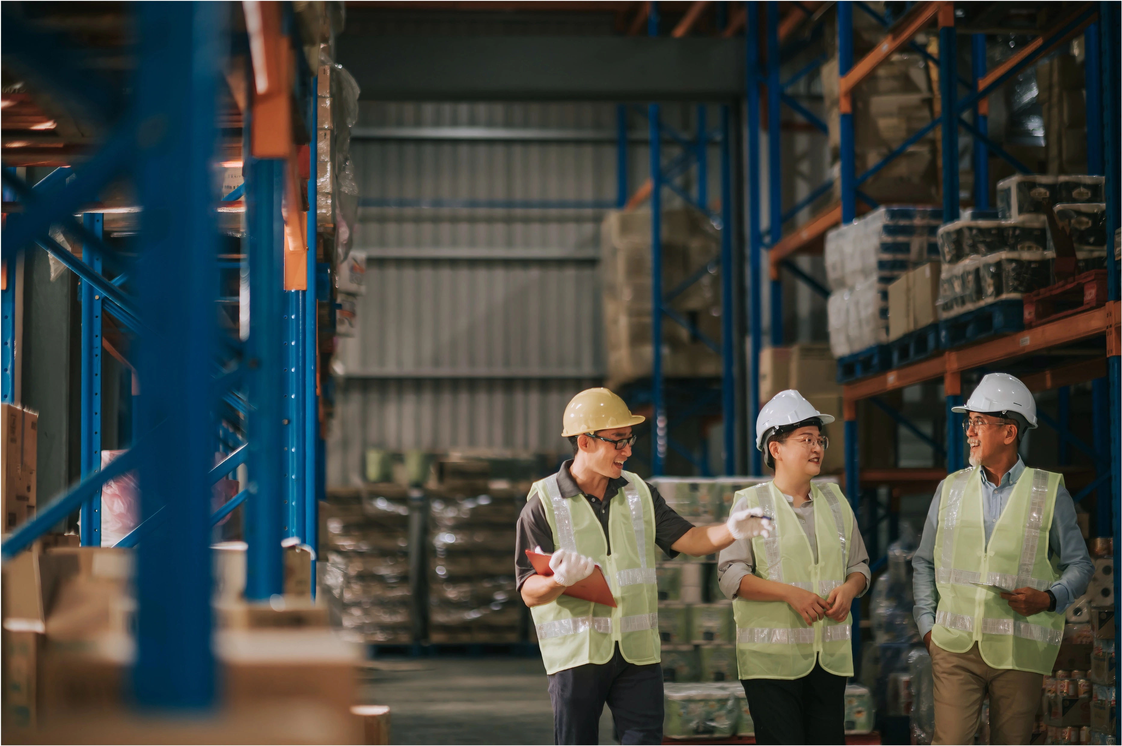 Operators in a warehouse discussing business operations.
