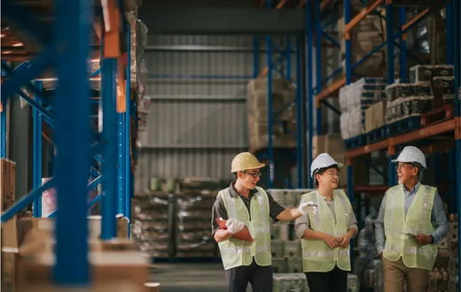 Operators in a warehouse discussing business operations.