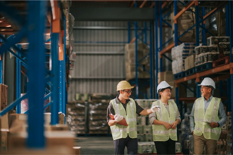 Operators in a warehouse discussing business operations.